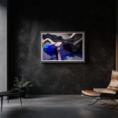 Shop 9 Modern art print of a woman with blue hair lying on the ground, framed and displayed on a dark wall in a contemporary living room with minimalist decor.